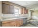 Dated kitchen featuring wood cabinets, worn countertops, a sink, and a dishwasher at 303 Clayton Rd, Auburndale, FL 33823