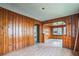 Spacious living room featuring wood paneling and an open layout with large windows that provides abundant natural light at 303 Clayton Rd, Auburndale, FL 33823
