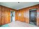 Living room with wood paneled walls, wood floors, and a view of the kitchen at 303 Clayton Rd, Auburndale, FL 33823