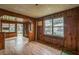 Warm living room with wood-paneled walls, spacious layout, and natural light from a window at 303 Clayton Rd, Auburndale, FL 33823