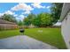 Spacious backyard featuring a well-maintained lawn, partial fencing, fire pit and a barbeque grill at 3826 Sleepy Hill Oaks Loop, Lakeland, FL 33810