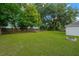 Large backyard featuring lush green grass and mature trees with a classic wooden fence at 3826 Sleepy Hill Oaks Loop, Lakeland, FL 33810