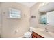 Bright bathroom with a wooden vanity, a large mirror, and a decorative shower curtain at 3826 Sleepy Hill Oaks Loop, Lakeland, FL 33810