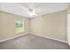 Neutral bedroom with carpet, a ceiling fan, and a bright window overlooking the backyard at 3826 Sleepy Hill Oaks Loop, Lakeland, FL 33810