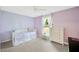 Cozy bedroom with soft purple walls, window, bed, and dresser at 3826 Sleepy Hill Oaks Loop, Lakeland, FL 33810