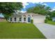 Charming single-story home featuring a well-manicured lawn, colorful flowerbeds, and a classic two-car garage at 3826 Sleepy Hill Oaks Loop, Lakeland, FL 33810