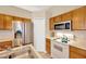 Functional kitchen features stainless steel refrigerator, white appliances, oak cabinetry and double sinks at 3826 Sleepy Hill Oaks Loop, Lakeland, FL 33810