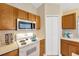 Traditional-style kitchen featuring wood cabinets, white appliances, and ample counter space at 3826 Sleepy Hill Oaks Loop, Lakeland, FL 33810