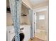 Bright laundry room featuring a modern washer and dryer with blue patterned privacy curtains at 3826 Sleepy Hill Oaks Loop, Lakeland, FL 33810