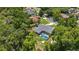 An aerial view of a home featuring a screened-in pool, mature trees, and surrounding neighborhood at 722 Swaying Palm Dr, Apopka, FL 32712