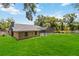 Well-maintained backyard featuring a screened-in porch, lush green grass, and mature trees, with a fenced perimeter at 722 Swaying Palm Dr, Apopka, FL 32712