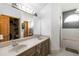 Bathroom featuring a double vanity sink, a large mirror, and a tub with shower at 722 Swaying Palm Dr, Apopka, FL 32712