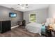 Bedroom features a desk, a window overlooking the backyard, a ceiling fan and wood floors at 722 Swaying Palm Dr, Apopka, FL 32712
