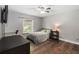 Bedroom with wood floors, a ceiling fan, a desk and a window overlooking the backyard at 722 Swaying Palm Dr, Apopka, FL 32712