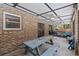 A covered brick patio with a ceiling fan, picnic table, and access to the outside and other parts of the home at 722 Swaying Palm Dr, Apopka, FL 32712