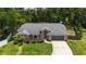 Aerial view of a brick home showcasing its well-manicured front yard, mature landscaping, and attached garage at 722 Swaying Palm Dr, Apopka, FL 32712