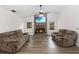 Comfortable living room with brick fireplace, ceiling fan, and hard wood floors at 722 Swaying Palm Dr, Apopka, FL 32712