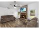 Cozy living room with brick fireplace, vaulted ceiling, and wood-look floors at 722 Swaying Palm Dr, Apopka, FL 32712