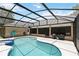 Outdoor pool area with a screened enclosure, poolside seating, and a spa. A covered outdoor living area is nearby at 722 Swaying Palm Dr, Apopka, FL 32712