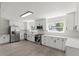 Bright kitchen featuring white cabinets, stainless steel appliances, modern lighting, and a large window at 837 E Edgewood Dr, Lakeland, FL 33803