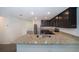 Open-concept kitchen with granite countertops, stainless steel appliances, and dark wood cabinets at 27 Perch Dr, Kissimmee, FL 34759