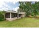 Spacious backyard with a screened-in porch, large trees, and a well-maintained lawn at 4462 Iris S St, Lakeland, FL 33813
