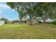 Spacious backyard featuring a well-kept lawn, mature trees, and a screened-in porch at 4462 Iris S St, Lakeland, FL 33813