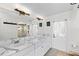 Bright bathroom features double sinks, marble countertops, large mirror, updated lighting, and tiled floors at 4462 Iris S St, Lakeland, FL 33813