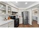 Kitchen showcasing stainless steel refrigerator, black stove top, white countertops and cabinetry with hardwood floors at 4462 Iris S St, Lakeland, FL 33813