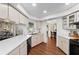 Bright kitchen features white cabinetry, sleek countertops and stainless steel sink, with warm wood-look flooring at 4462 Iris S St, Lakeland, FL 33813