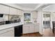 Kitchen featuring white cabinets, modern countertops, stainless steel sink, and black dishwasher with a view to the yard at 4462 Iris S St, Lakeland, FL 33813
