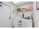 Functional laundry room with washer, dryer, utility shelving for storage and a white door at 4462 Iris S St, Lakeland, FL 33813
