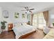 Bright main bedroom offers hardwood floors, ceiling fan, natural light, and stylish decor at 4462 Iris S St, Lakeland, FL 33813