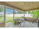 View of a screened patio with a small table, chairs, and a hammock at 4462 Iris S St, Lakeland, FL 33813