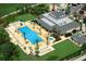 Aerial view of a community pool with palm trees, a pool house, and lounge chairs at 7810 Whitemarsh Way, Reunion, FL 34747