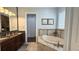 Elegant bathroom featuring soaking tub and double vanity with granite counters at 7810 Whitemarsh Way, Reunion, FL 34747