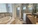 Elegant bathroom featuring soaking tub, glass shower, and double vanity at 7810 Whitemarsh Way, Reunion, FL 34747
