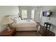 Serene bedroom with a queen bed, natural light, television and hardwood flooring at 7810 Whitemarsh Way, Reunion, FL 34747