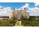 Exterior shot of high-rise building with multiple balconies, lush landscaping, and a circular driveway entrance at 7810 Whitemarsh Way, Reunion, FL 34747