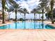 A lovely pool surrounded by palm trees and lounge chairs on a bright sunny day at 7810 Whitemarsh Way, Reunion, FL 34747