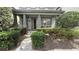 Inviting front porch with lush landscaping and stylish gray columns gives a warm welcome at 7810 Whitemarsh Way, Reunion, FL 34747