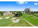 Scenic aerial view of a golf course featuring sand traps, fairways, and a building in the background at 7810 Whitemarsh Way, Reunion, FL 34747