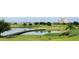 Lush golf course featuring a lake with a walking bridge connecting various sections of the green at 7810 Whitemarsh Way, Reunion, FL 34747