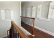 Hallway featuring wood floors, decorative wall accents, and railing at 7810 Whitemarsh Way, Reunion, FL 34747