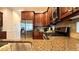 Gourmet kitchen featuring granite countertops, stainless steel appliances, dark wood cabinetry, and a gas cooktop at 7810 Whitemarsh Way, Reunion, FL 34747