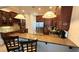 Eat in kitchen area featuring dark wood cabinetry, granite countertops, stainless steel appliances and pendant lighting at 7810 Whitemarsh Way, Reunion, FL 34747