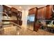 Gourmet kitchen with granite countertops, stainless steel appliances, dark wood cabinetry, and decorative backsplash at 7810 Whitemarsh Way, Reunion, FL 34747