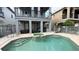 Resort style pool area featuring a spa, putting green, covered patio, and fenced yard for ideal outdoor enjoyment at 7810 Whitemarsh Way, Reunion, FL 34747