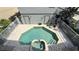 Aerial view of the backyard pool and jacuzzi surrounded by brick pavers and white fencing at 7810 Whitemarsh Way, Reunion, FL 34747