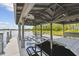 Covered boat lift on a private dock offering convenient lake access and scenic waterfront views at 9080 Morgana Ct, Winter Garden, FL 34787